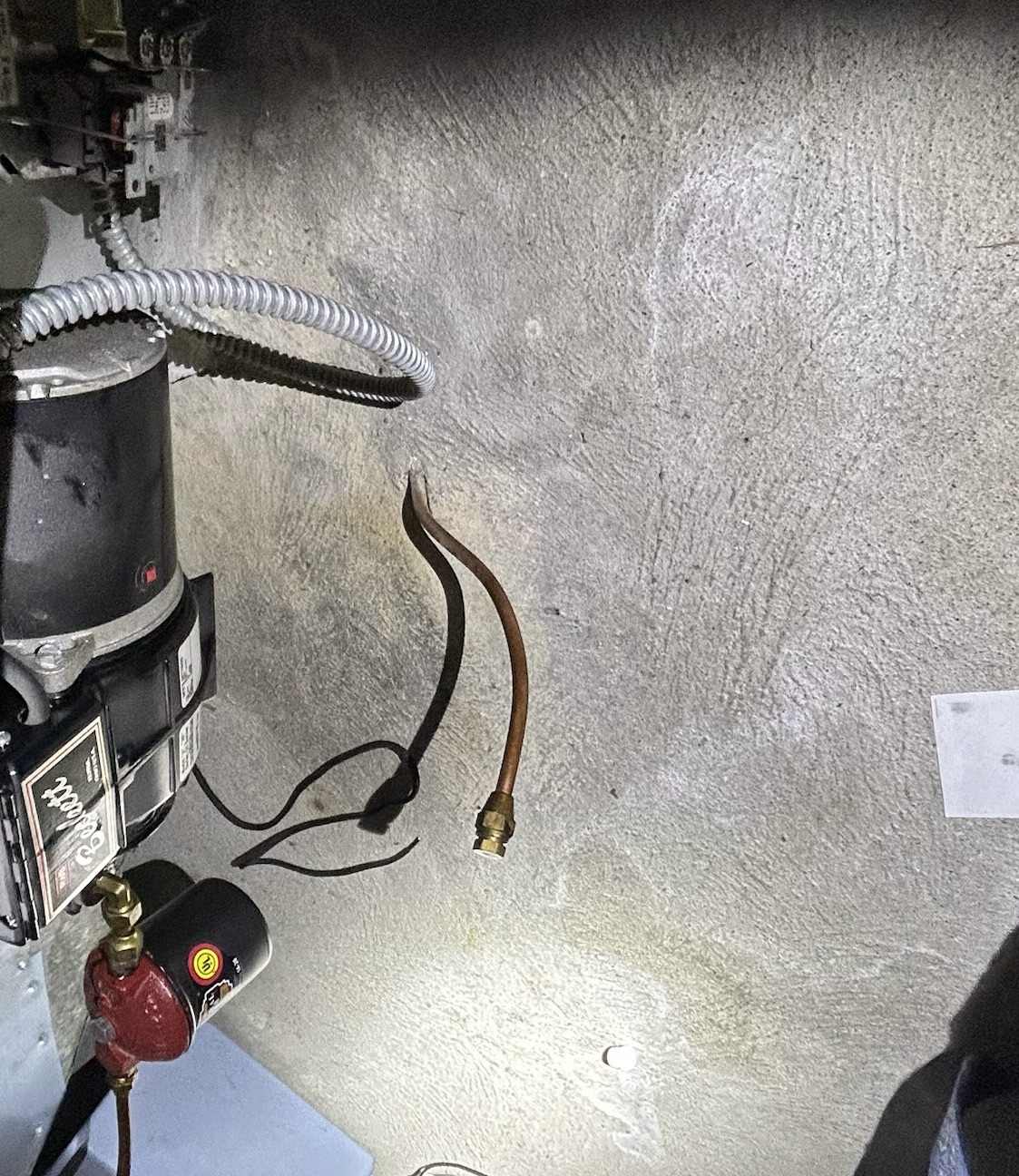 Oil line penetration through foundation wall showing possible buried oil tank connection in Vancouver Island home