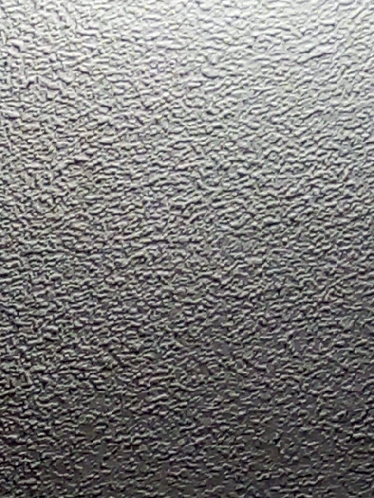 Close-up of a textured ceiling finish that resembles popcorn or stipple texture